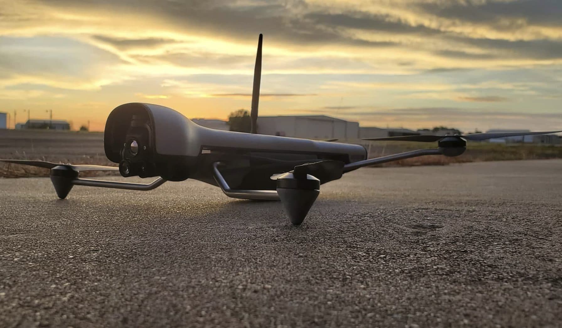 A fixed-wing drone on the ground at dusk, ready for a flight test